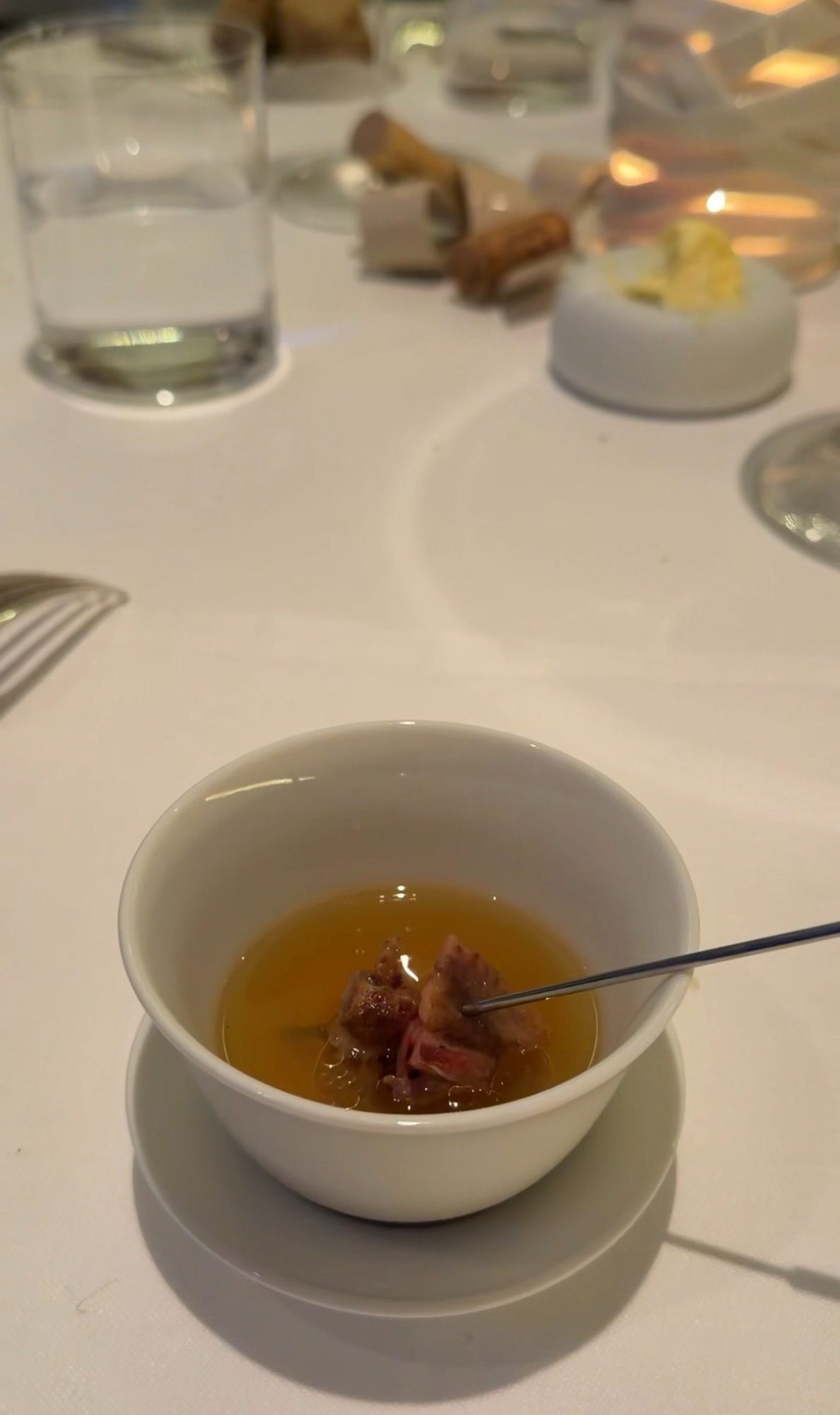 Clear golden broth with pieces of meat at Restaurant Alliance