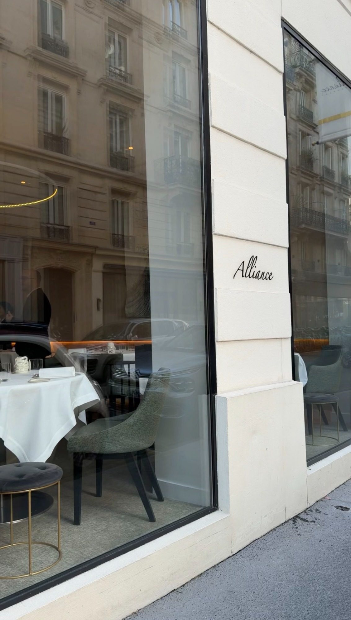 The Alliance restaurant exterior on rue de Poissy in Paris, with the name on the stone and the dining room visible through the window
