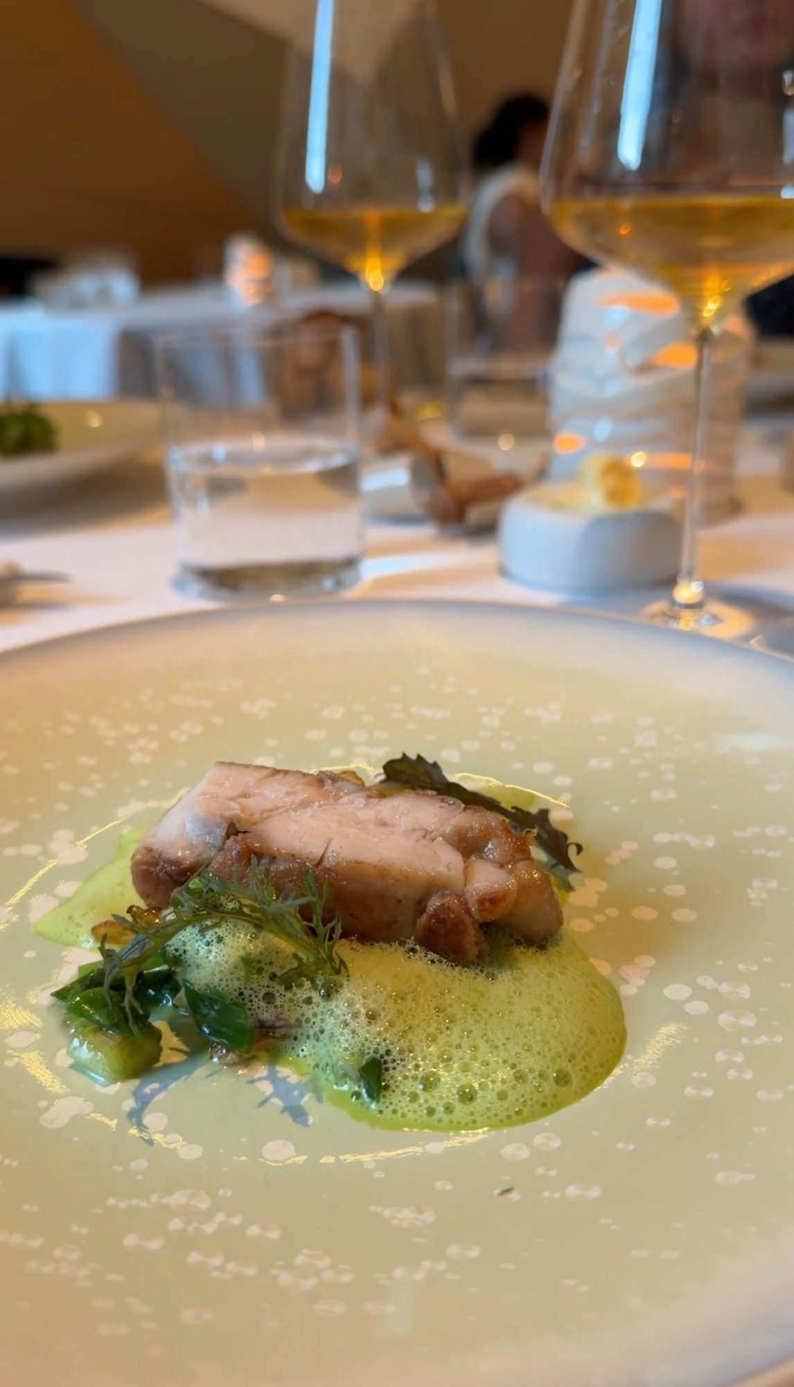 Sliced pale meat on a green foamy sauce at Restaurant Alliance Paris