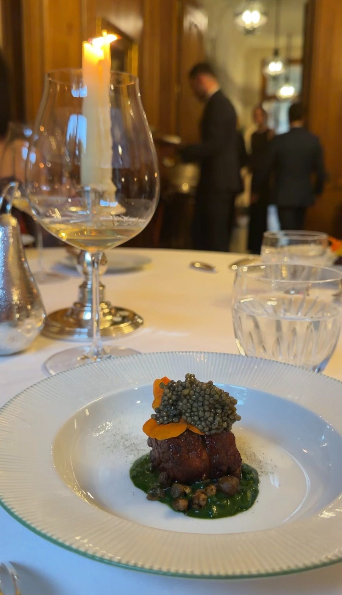 A square of meat topped with caviar and carrot on a green sauce at Le Clarence