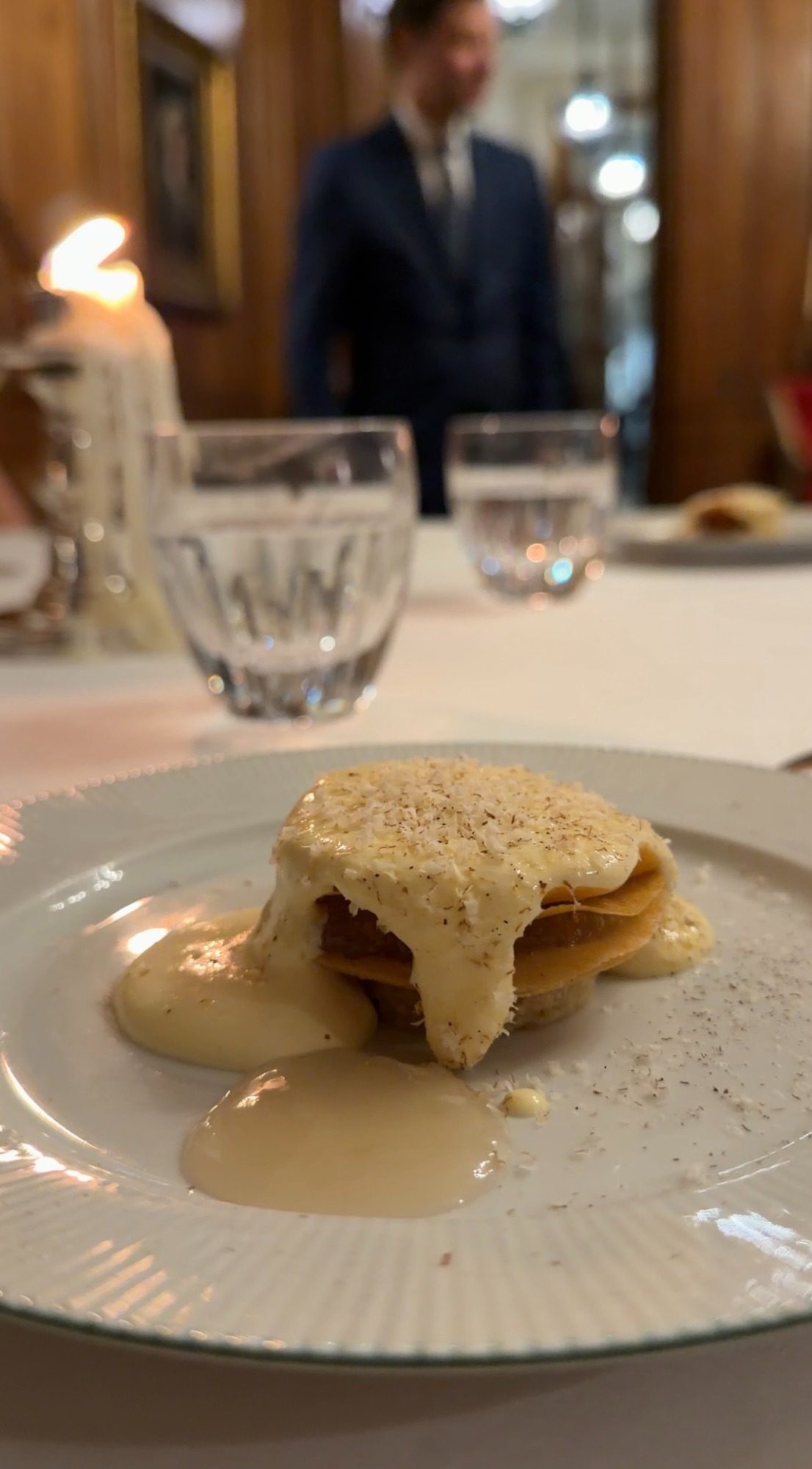 A stacked dish under a pale cheese sauce at Le Clarence in Paris