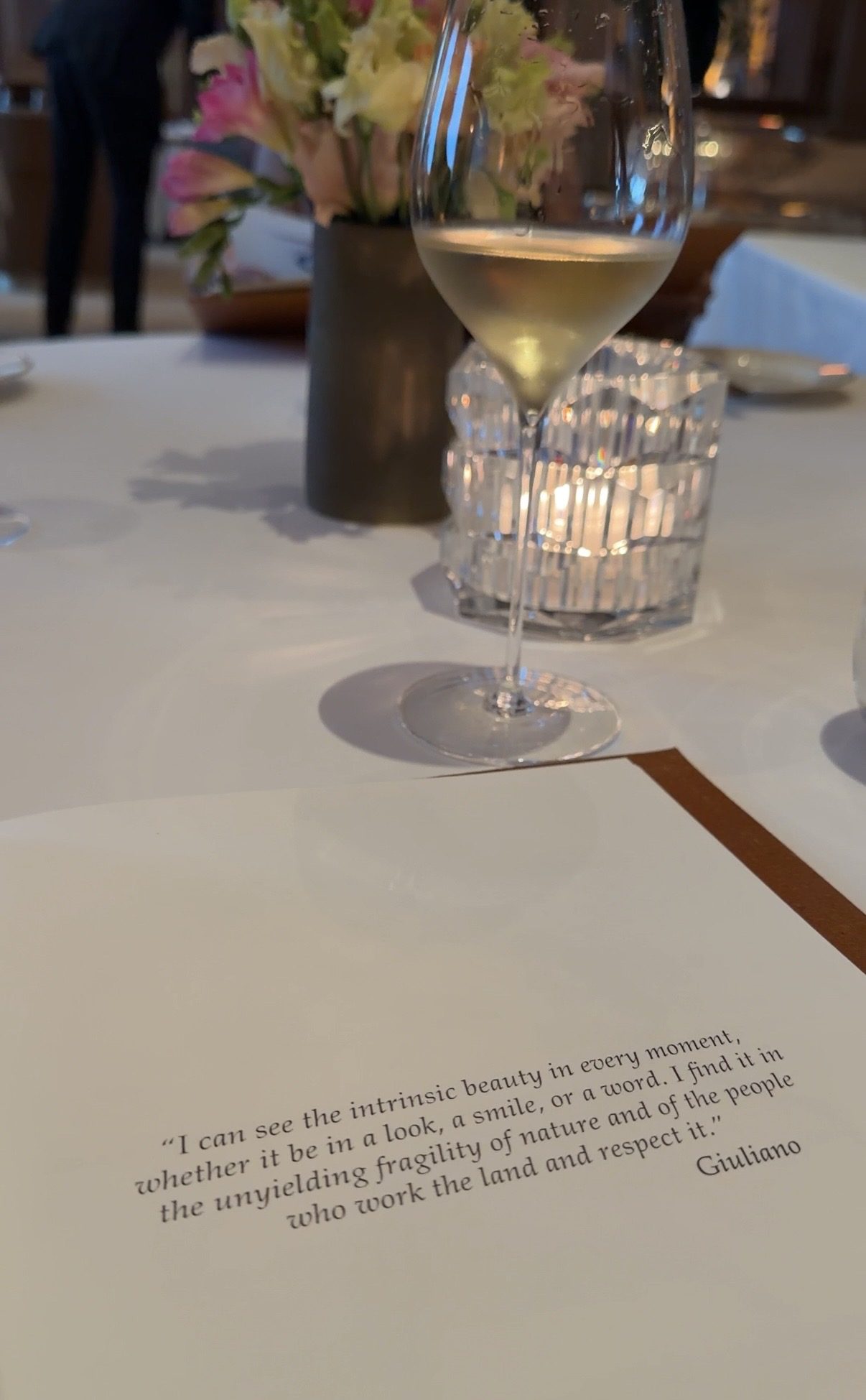 Le Taillevent menu card quoting chef Giuliano Sperandio, with white wine and a candle