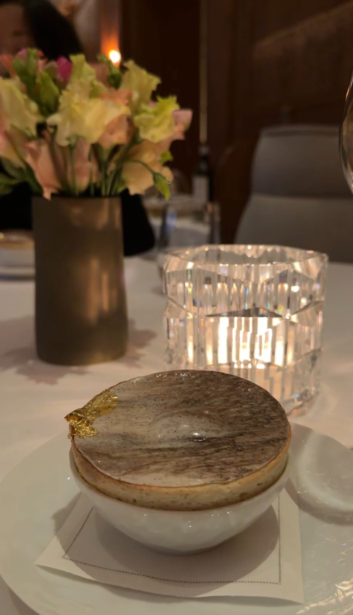 Browned dessert with gold leaf in a white bowl at Le Taillevent