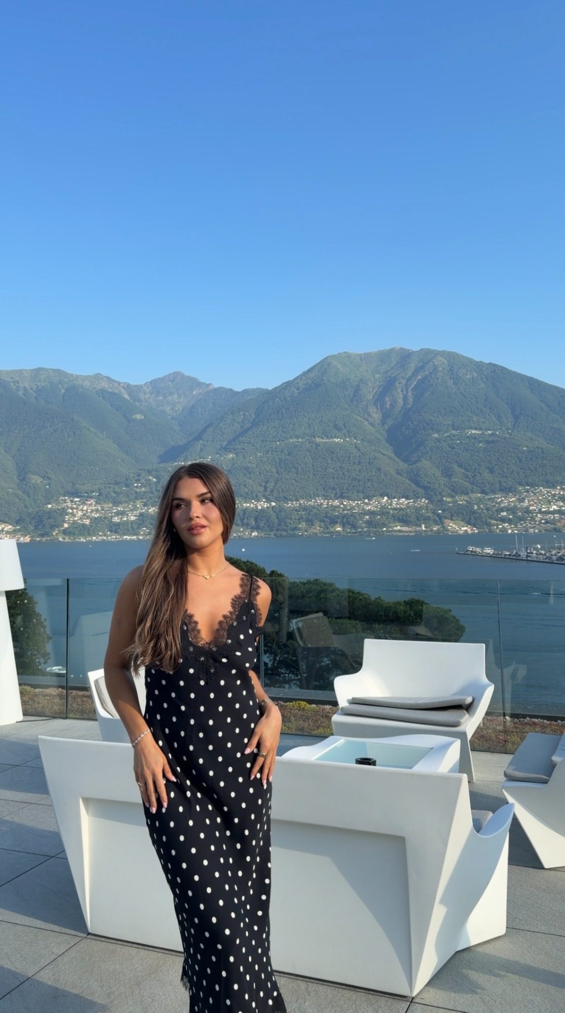 Jess in a black polka-dot dress on a terrace above Lake Maggiore in Locarno, Switzerland