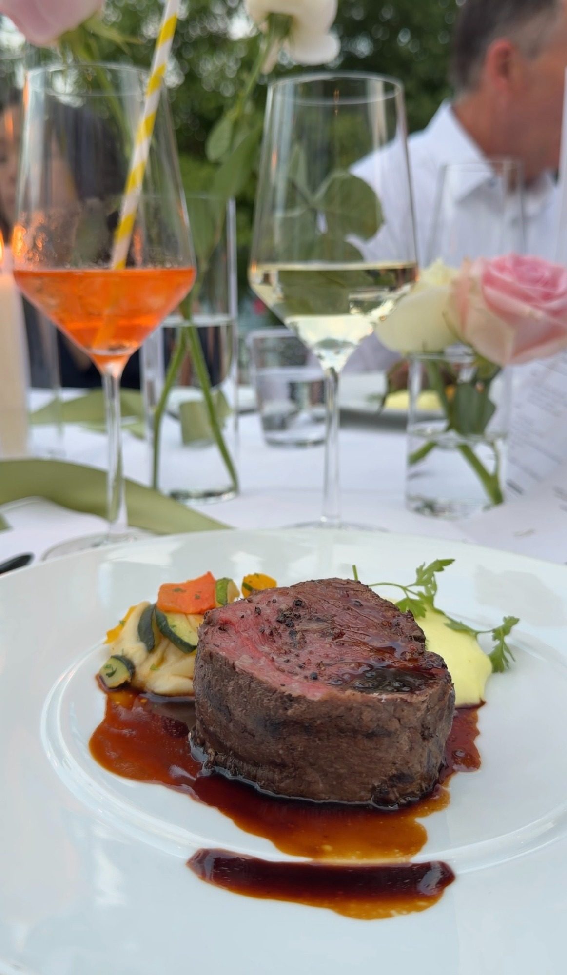 Steak with vegetables and wine at an outdoor dinner in Locarno, Switzerland