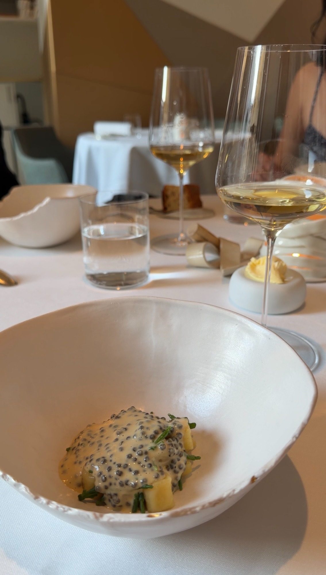 Caviar, potato, and herbs in a white bowl at a Paris birthday dinner