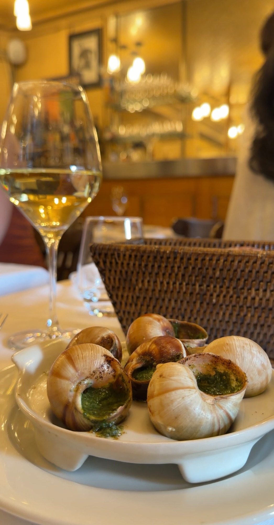 Escargot in garlic butter with a glass of white wine at a Paris restaurant