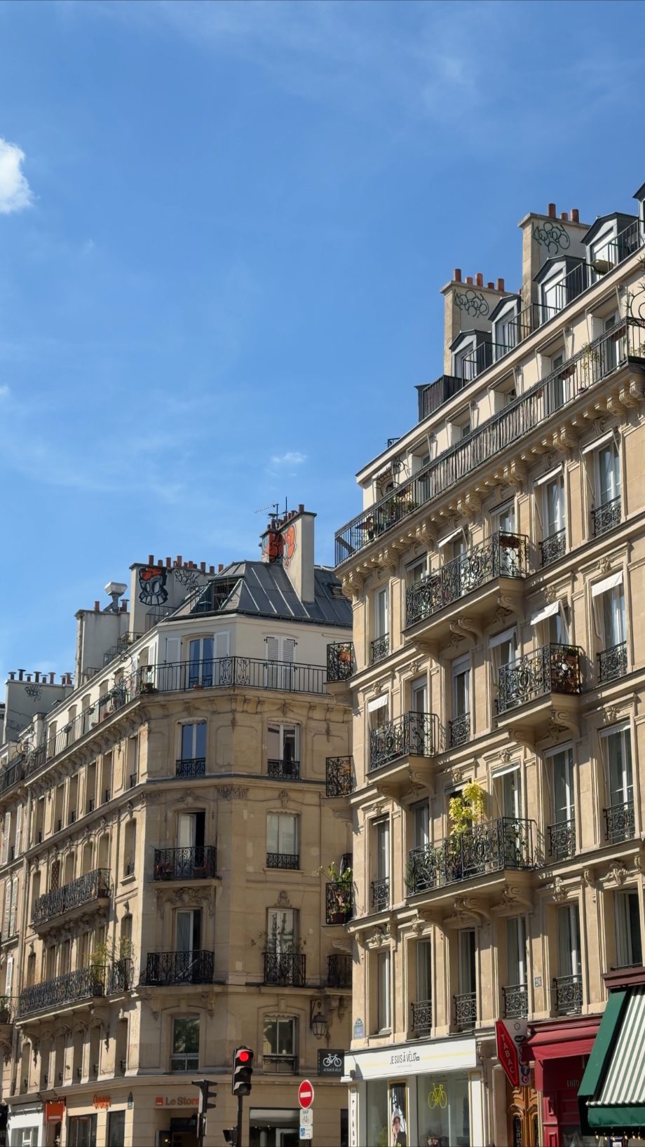 Haussmann apartment buildings with iron balconies under a blue sky in Paris